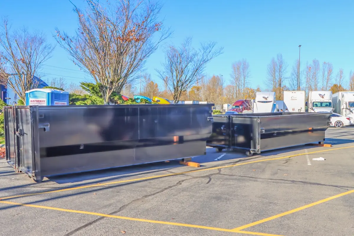 Professional dumpster rental service with roll-off container on residential driveway in Alpena